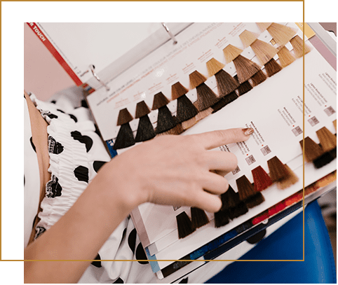 A woman is looking at hair color samples.